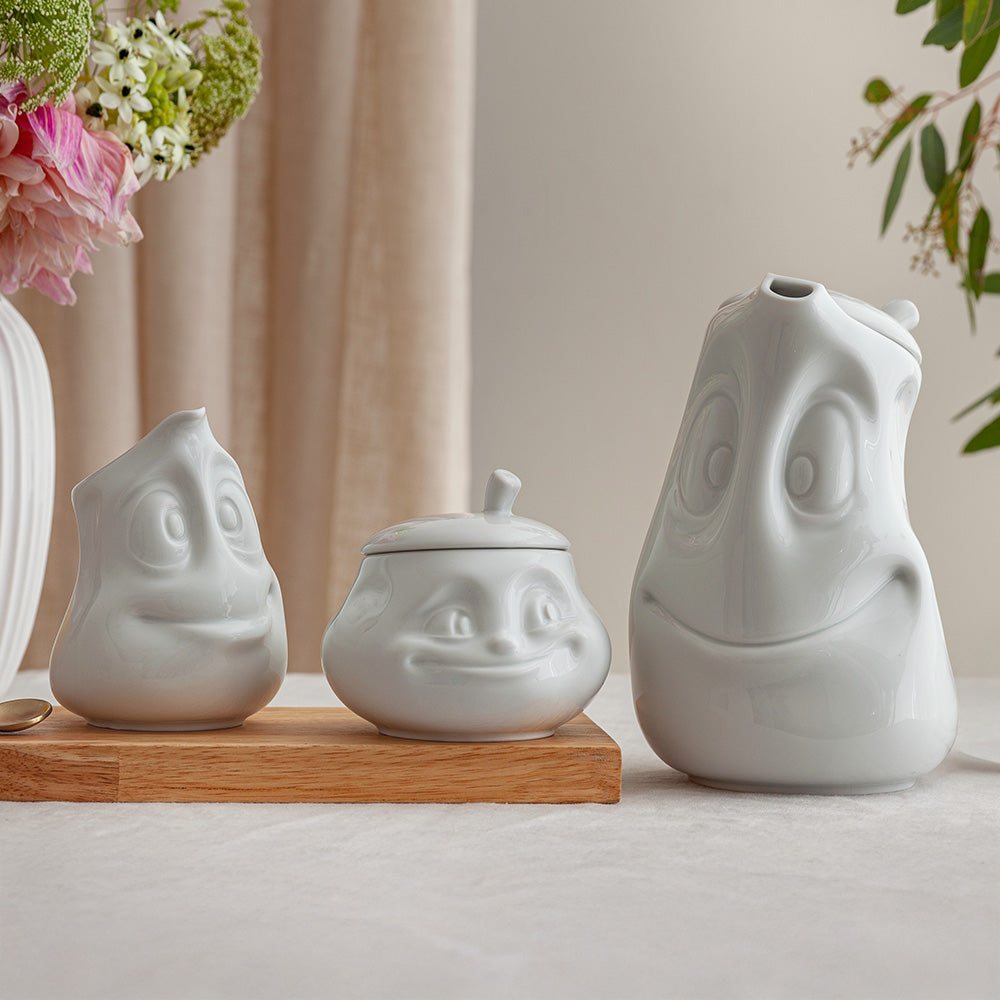 Porcelain tea pot in white featuring a 'good mood' facial expression and a generous 40 oz. capacity. Perfect for serving tea, coffee, punch, mulled wine and more. Detailed facial expression tea pot from the porcelain product family of fun dishware by FIFTYEIGHT Products. Shipped in exclusively designed gift box.