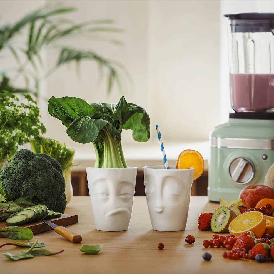 Set of two coffee mugs without handles in white from the porcelain product family of fun dishware by FIFTYEIGHT Products. Each offering 11 oz capacity. Dishwasher and microwave safe coffee cups with a 'snoozy' and one with a 'kissing' facial expression. Shipped in exclusively designed gift box.