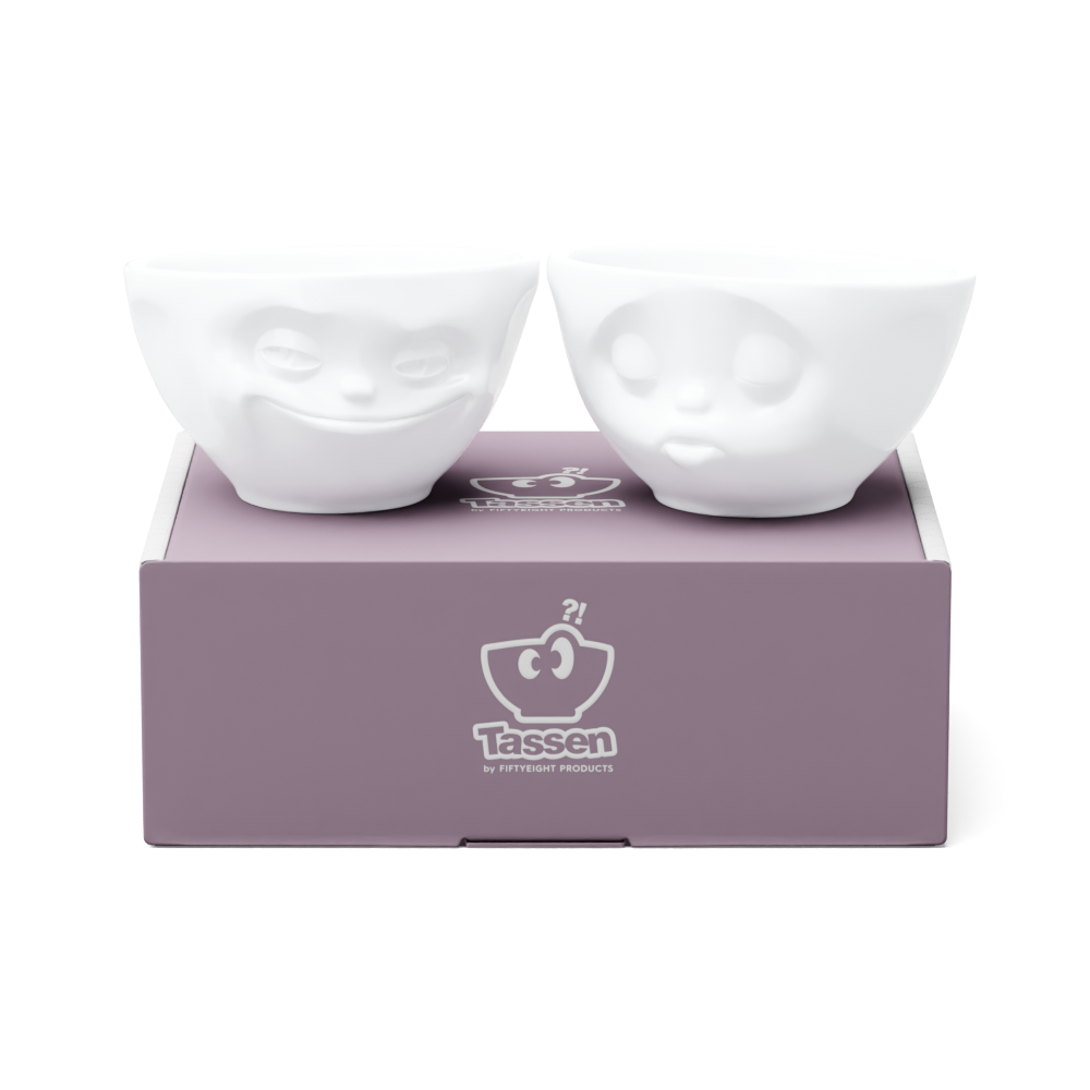 Set of two 6.5 oz. bowls in white from the porcelain product family of fun dishware by FIFTYEIGHT Products. Perfect for serving snacks, nuts, chips, dips, sauces, and a few scoops of ice cream. Dishwasher and microwave safe bowls featuring sculpted ‘grinning’ and 'kissing' faces. Shipped in exclusively designed gift box.