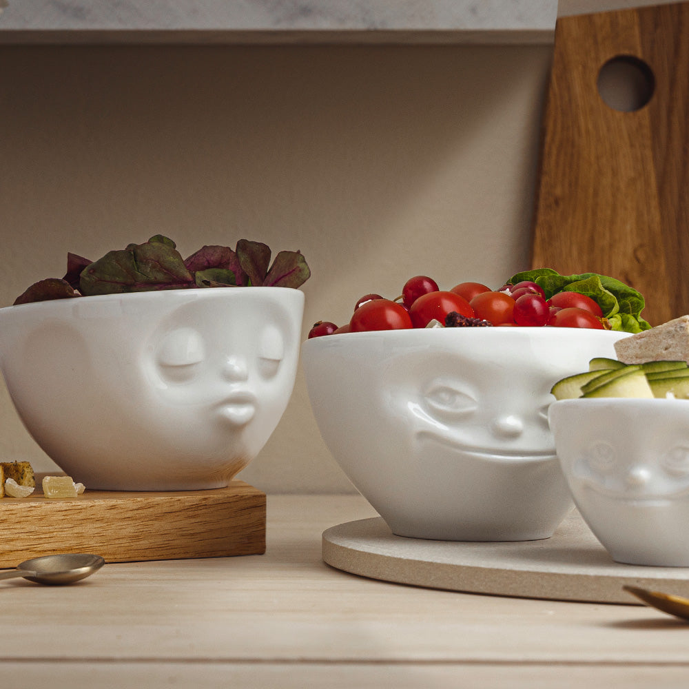Set of two 6.5 oz. bowls in white from the porcelain product family of fun dishware by FIFTYEIGHT Products. Perfect for serving snacks, nuts, chips, dips, sauces, and a few scoops of ice cream. Dishwasher and microwave safe bowls featuring sculpted ‘grinning’ and 'kissing' faces. Shipped in exclusively designed gift box.