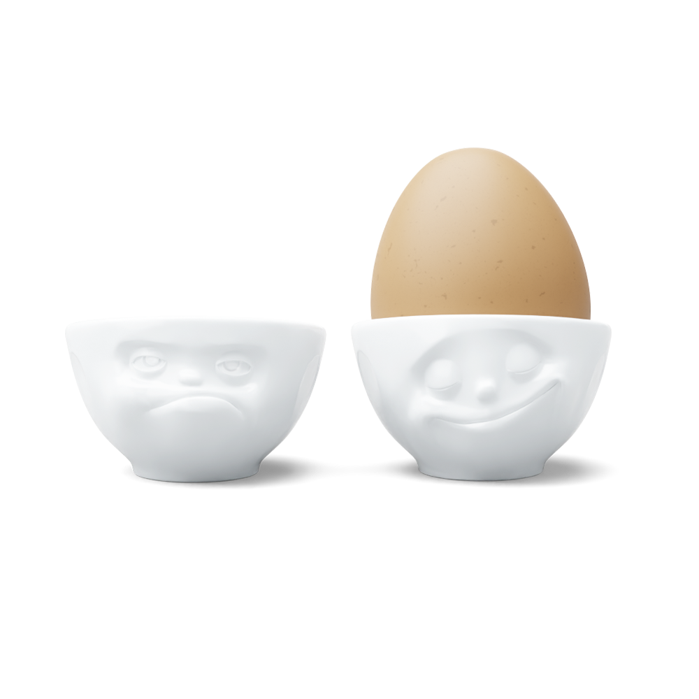 Set of two egg cups in white from the porcelain product family of fun dishware by FIFTYEIGHT Products. Set features two egg cups in white, featuring 'Happy' and 'Hmpff' facial expressions. Dishwasher and microwave safe bowls. Shipped in exclusively designed gift box.