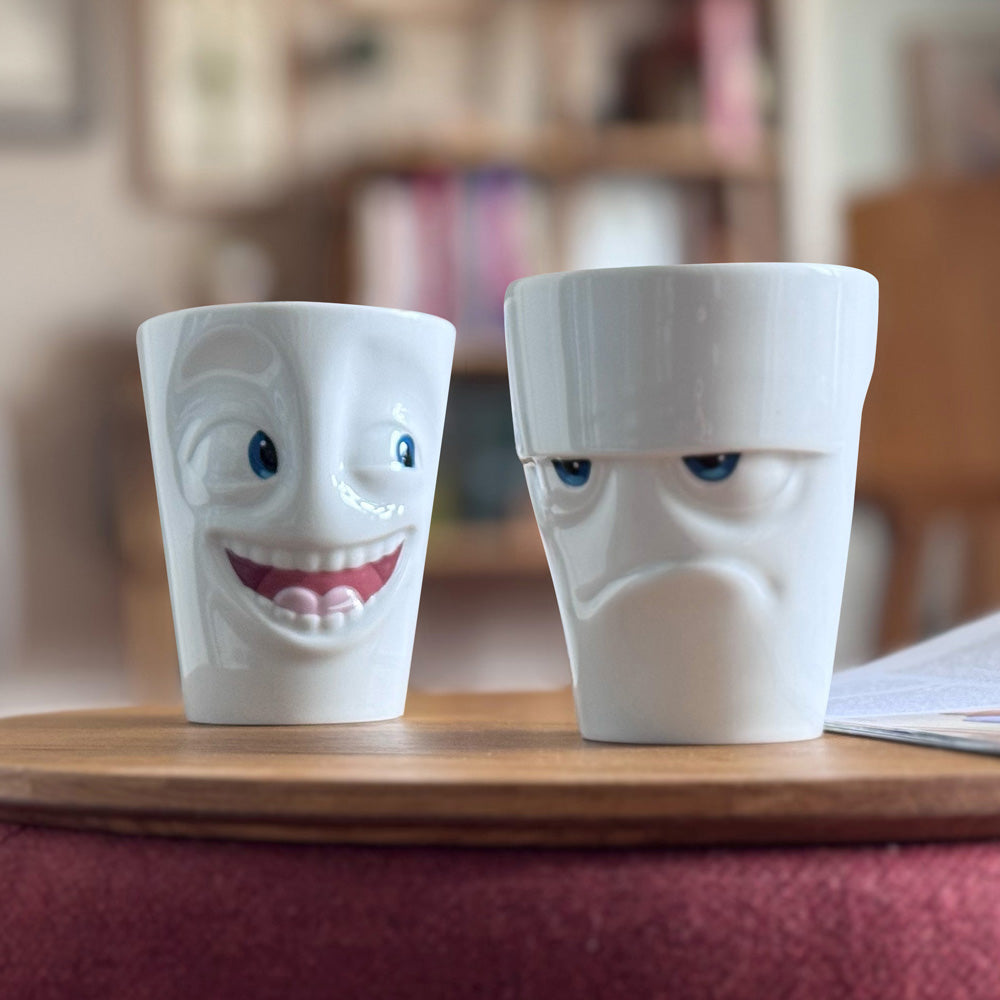 Premium porcelain coffee mug with handle from the popular porcelain family of fun dishware by FIFTYEIGHT Products. Special art edition with colorful accents applied by hand. Offers 11 oz capacity for serving coffee, tea, latte, matcha, soup and more. Dishwasher and microwave safe cup with a 'joking' facial expression. Shipped in exclusively designed gift box.