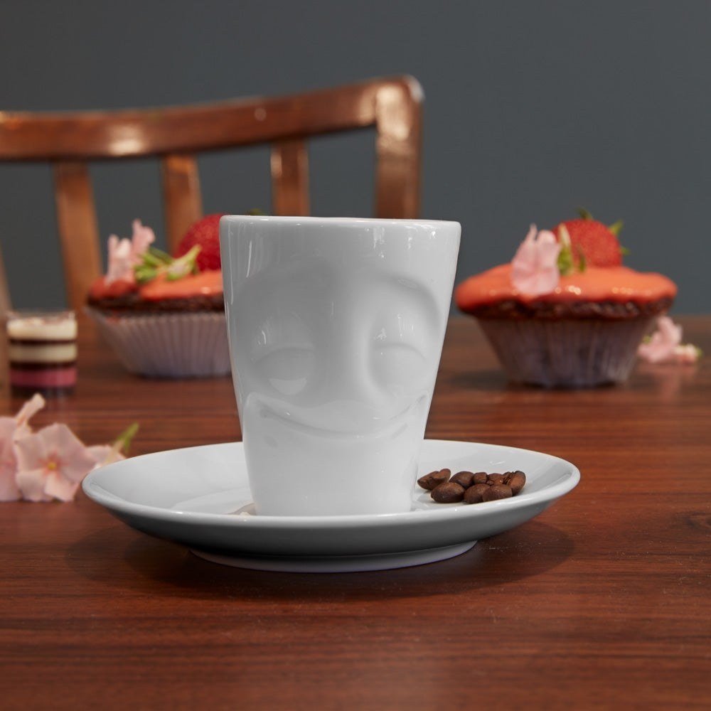 Premium porcelain espresso cup with saucer in white from the porcelain product family of fun dishware by FIFTYEIGHT Products. Offers 2.7 oz capacity and comes with a matching saucer. Dishwasher and microwave safe cup with an 'cheery' facial expression. Shipped in exclusively designed gift box.