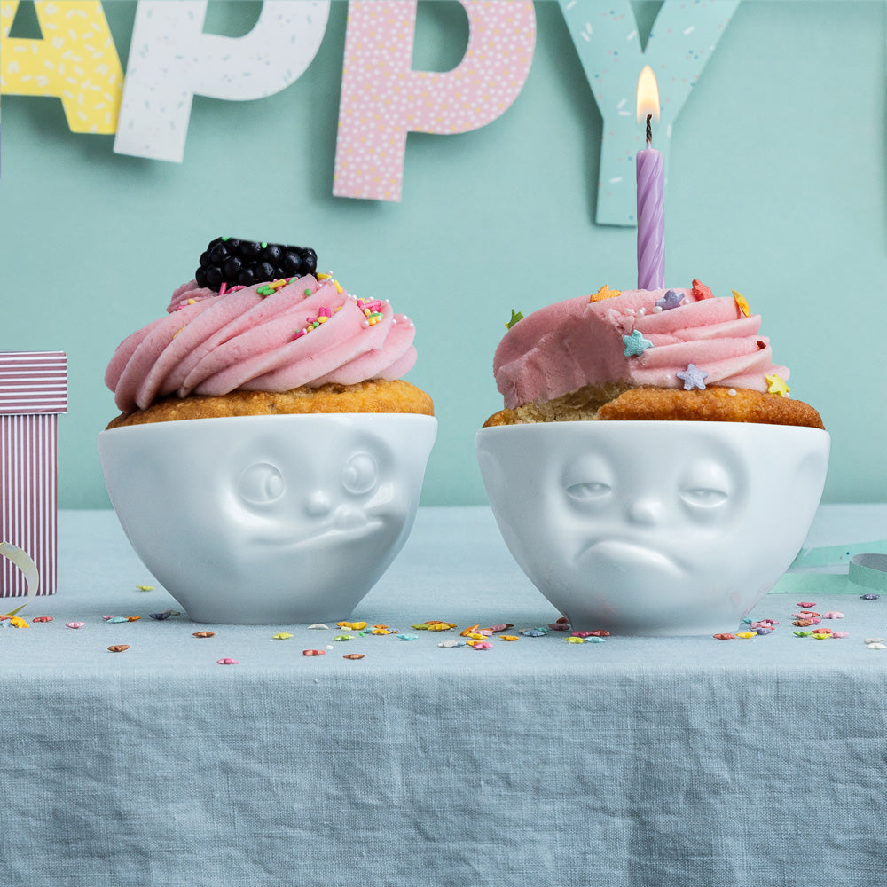 Set of two 6.5 oz. bowls in white from the porcelain product family of fun dishware by FIFTYEIGHT Products. Perfect for serving snacks, nuts, chips, dips, sauces, and a few scoops of ice cream. Dishwasher and microwave safe bowls featuring sculpted ‘tasty’ and 'snoozy' faces. Shipped in exclusively designed gift box.