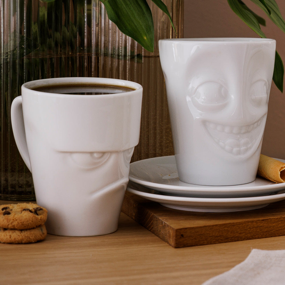 Premium porcelain coffee mug with handle from the porcelain product family of fun dishware by FIFTYEIGHT Products. Offers 11 oz capacity for serving coffee, tea, latte, matcha, soup and more. Dishwasher and microwave safe cup with a 'joking' facial expression. Shipped in exclusively designed gift box.