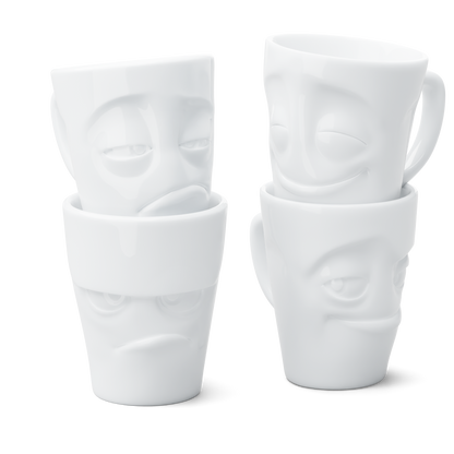 Set of four white porcelain mugs with face designs on a white background