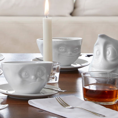 Premium porcelain coffee cup with saucer in white from the porcelain product family of fun dishware by FIFTYEIGHT Products. Offers 6.5 oz capacity and comes with a matching saucer. Dishwasher and microwave safe cup with a 'grinning' facial expression. Shipped in exclusively designed gift box.