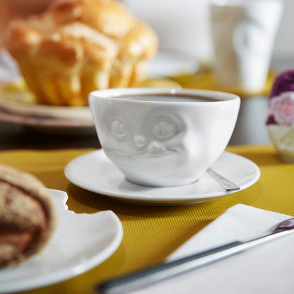 Premium porcelain coffee cup with saucer in white from the porcelain product family of fun dishware by FIFTYEIGHT Products. Offers 6.5 oz capacity and comes with a matching saucer. Dishwasher and microwave safe cup with a 'tasty' facial expression. Shipped in exclusively designed gift box.