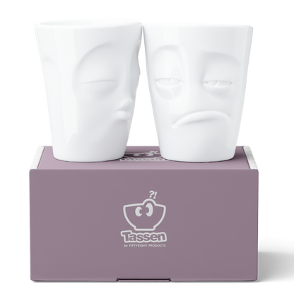 Set of two coffee mugs without handles in white from the porcelain product family of fun dishware by FIFTYEIGHT Products. Each offering 11 oz capacity. Dishwasher and microwave safe coffee cups with a 'snoozy' and one with a 'kissing' facial expression. Shipped in exclusively designed gift box.