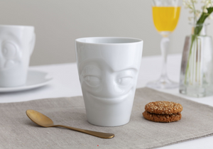 Coffee mug with 'impish' facial expression and 11 oz capacity. From the TASSEN product family of fun dishware by FIFTYEIGHT Products. Tall coffee cup with handle in white, crafted from quality porcelain.