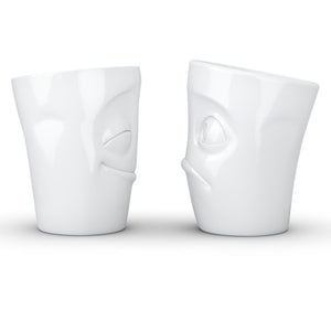 Set of two coffee mugs with 'Cheery' and 'Baffled' facial expression and 11 oz capacity. From the TASSEN product family of fun dishware by FIFTYEIGHT Products. Tall coffee cups without handles in white, crafted from quality porcelain.