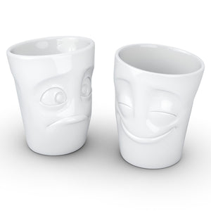 Set of two coffee mugs with 'Cheery' and 'Baffled' facial expression and 11 oz capacity. From the TASSEN product family of fun dishware by FIFTYEIGHT Products. Tall coffee cups without handles in white, crafted from quality porcelain.