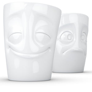 Set of two coffee mugs with 'Cheery' and 'Baffled' facial expression and 11 oz capacity. From the TASSEN product family of fun dishware by FIFTYEIGHT Products. Tall coffee cups without handles in white, crafted from quality porcelain.