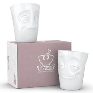 Set of two coffee mugs with 'Cheery' and 'Baffled' facial expression and 11 oz capacity. From the TASSEN product family of fun dishware by FIFTYEIGHT Products. Tall coffee cups without handles in white, crafted from quality porcelain.