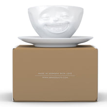 Load image into Gallery viewer, Coffee cup with a &#39;laughing&#39; facial expression and 6.5 oz capacity. From the TASSEN product family of fun dishware by FIFTYEIGHT Products. Coffee cup with matching saucer crafted from quality porcelain.
