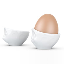 Load image into Gallery viewer, Set of two egg cups in white from the TASSEN product family of fun dishware by FIFTYEIGHT Products. Set features two egg cups in white, featuring &#39;kissing&#39; and &#39;dreamy&#39; facial expressions. Dishwasher and microwave safe bowls. Shipped in exclusively designed gift box.
