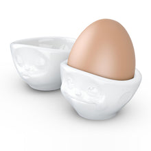 Load image into Gallery viewer, Set of two egg cups in white from the TASSEN product family of fun dishware by FIFTYEIGHT Products. Set features two egg cups in white, featuring &#39;kissing&#39; and &#39;dreamy&#39; facial expressions. Dishwasher and microwave safe bowls. Shipped in exclusively designed gift box.
