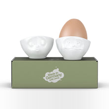Load image into Gallery viewer, Set of two egg cups in white from the TASSEN product family of fun dishware by FIFTYEIGHT Products. Set features two egg cups in white, featuring &#39;kissing&#39; and &#39;dreamy&#39; facial expressions. Dishwasher and microwave safe bowls. Shipped in exclusively designed gift box.

