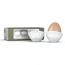 Load image into Gallery viewer, Set of two egg cups in white from the TASSEN product family of fun dishware by FIFTYEIGHT Products. Set features two egg cups in white, featuring &#39;kissing&#39; and &#39;dreamy&#39; facial expressions. Dishwasher and microwave safe bowls. Shipped in exclusively designed gift box.
