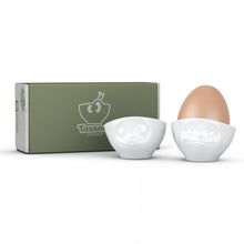 Load image into Gallery viewer, Set of two egg cups in white from the TASSEN product family of fun dishware by FIFTYEIGHT Products. Set features two egg cups in white, featuring &#39;kissing&#39; and &#39;dreamy&#39; facial expressions. Dishwasher and microwave safe bowls. Shipped in exclusively designed gift box.

