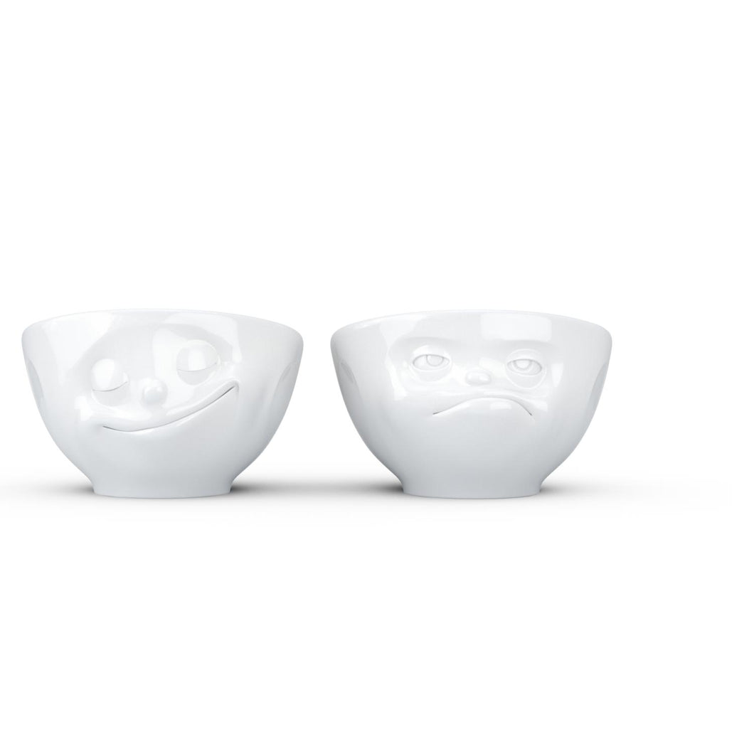 Set of two egg cups in white from the TASSEN product family of fun dishware by FIFTYEIGHT Products. Set features two egg cups in white, featuring 'Happy' and 'Hmpff' facial expressions. Dishwasher and microwave safe bowls. Shipped in exclusively designed gift box.