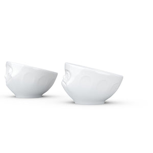 Set of two egg cups in white from the TASSEN product family of fun dishware by FIFTYEIGHT Products. Set features two egg cups in white, featuring 'Happy' and 'Hmpff' facial expressions. Dishwasher and microwave safe bowls. Shipped in exclusively designed gift box.