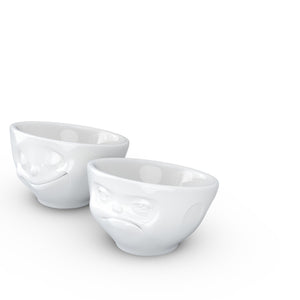 Set of two egg cups in white from the TASSEN product family of fun dishware by FIFTYEIGHT Products. Set features two egg cups in white, featuring 'Happy' and 'Hmpff' facial expressions. Dishwasher and microwave safe bowls. Shipped in exclusively designed gift box.