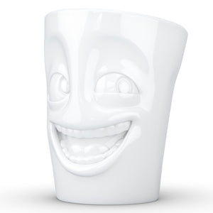 Coffee mug with 'joking' facial expression and 11 oz capacity. From the TASSEN product family of fun dishware by FIFTYEIGHT Products. Tall coffee cup with handle in white, crafted from quality porcelain.