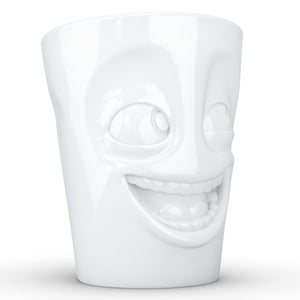 Coffee mug with 'joking' facial expression and 11 oz capacity. From the TASSEN product family of fun dishware by FIFTYEIGHT Products. Tall coffee cup with handle in white, crafted from quality porcelain.