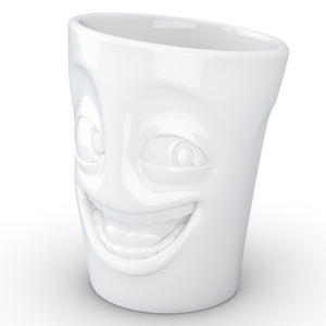 Coffee mug with 'joking' facial expression and 11 oz capacity. From the TASSEN product family of fun dishware by FIFTYEIGHT Products. Tall coffee cup with handle in white, crafted from quality porcelain.