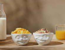 Load image into Gallery viewer, Set of two 6.5 oz. bowls in white from the TASSEN product family featuring sculpted Laughing and Winking faces.
