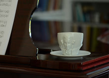 Load image into Gallery viewer, Premium porcelain coffee cup with saucer in white with sculpted Wolfgang Amadeus Mozart face. Dishwasher and microwave safe cup at 8.7 oz capacity. From the TALENT product family of cups dedicated to creative geniuses by FIFTYEIGHT Products.
