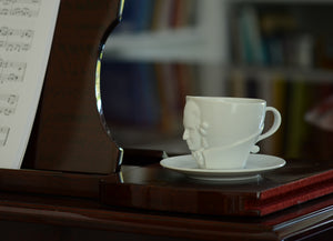 Premium porcelain coffee cup with saucer in white with sculpted Wolfgang Amadeus Mozart face. Dishwasher and microwave safe cup at 8.7 oz capacity. From the TALENT product family of cups dedicated to creative geniuses by FIFTYEIGHT Products.